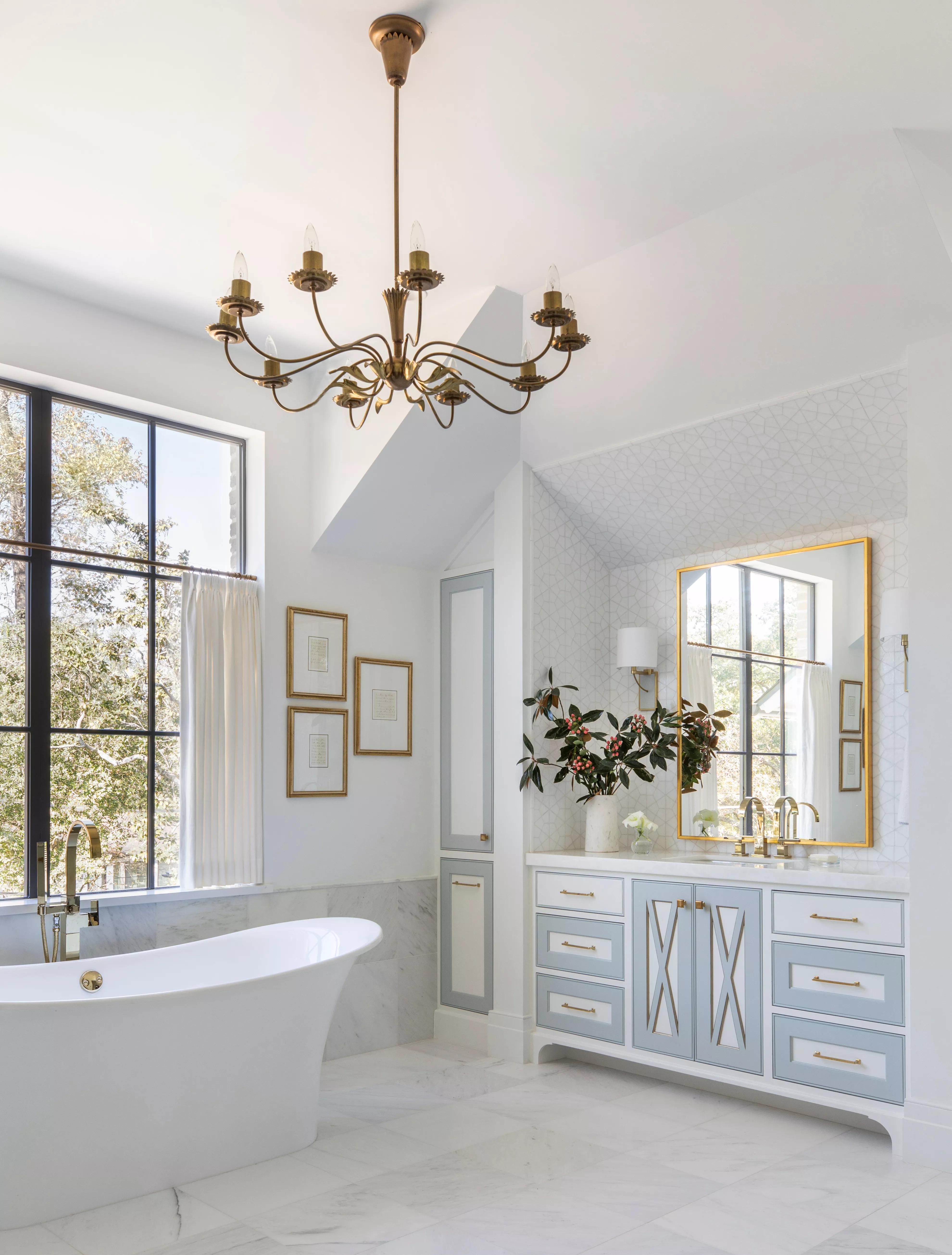 Bathroom with white walls and tub and a gold chandelier