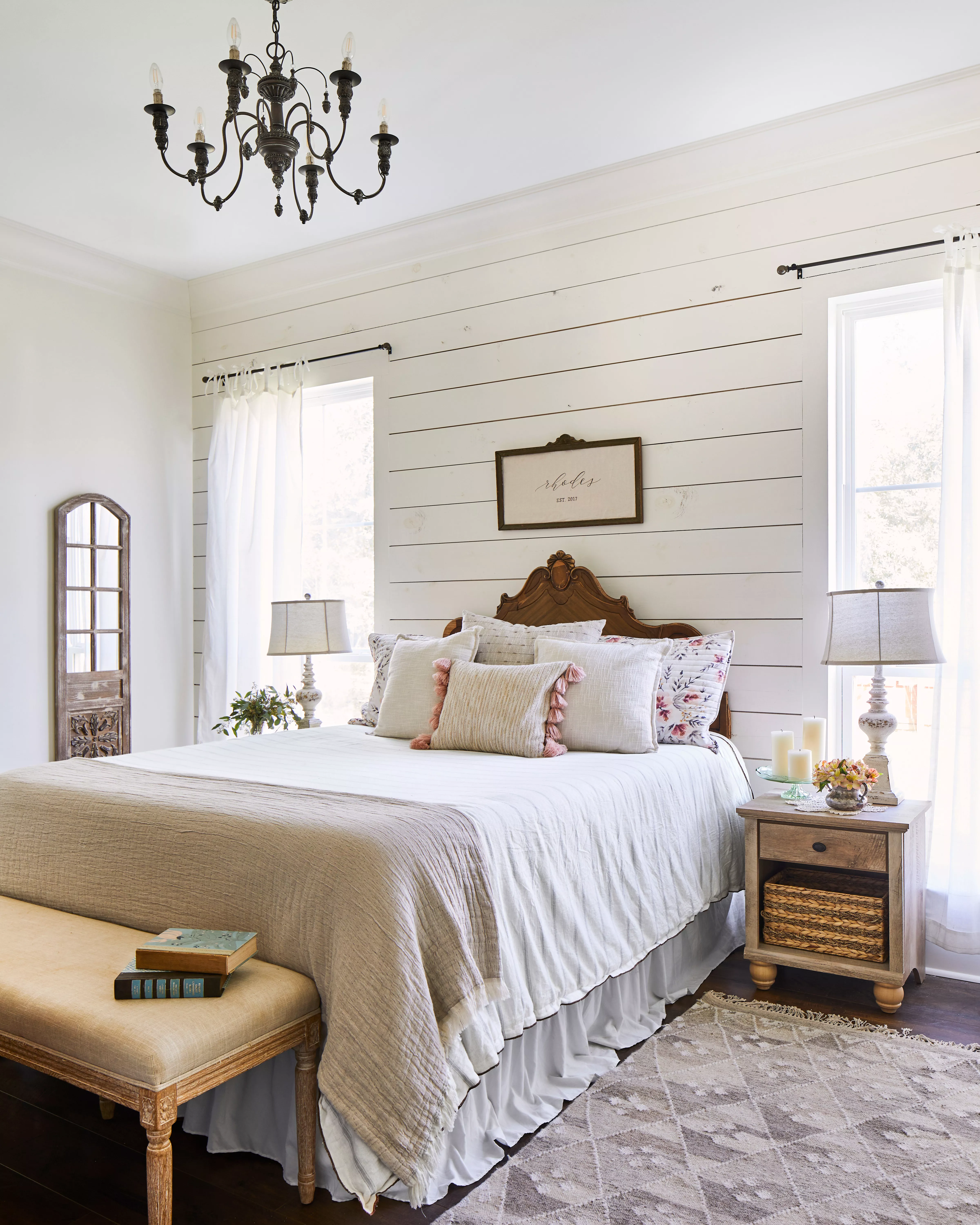 Shiplap bedroom with black chandelier and white bedding